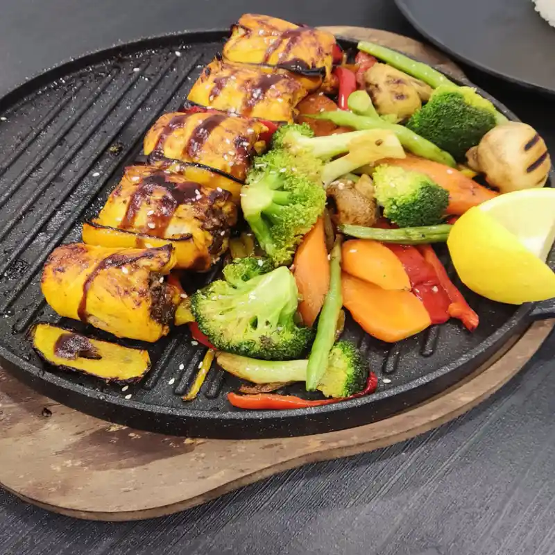 رول گریل‌شده با سس مخصوص و سبزیجات گریل روی صفحه چدنی؛ خروجی دوره آموزش انواع کباب کلید هنر